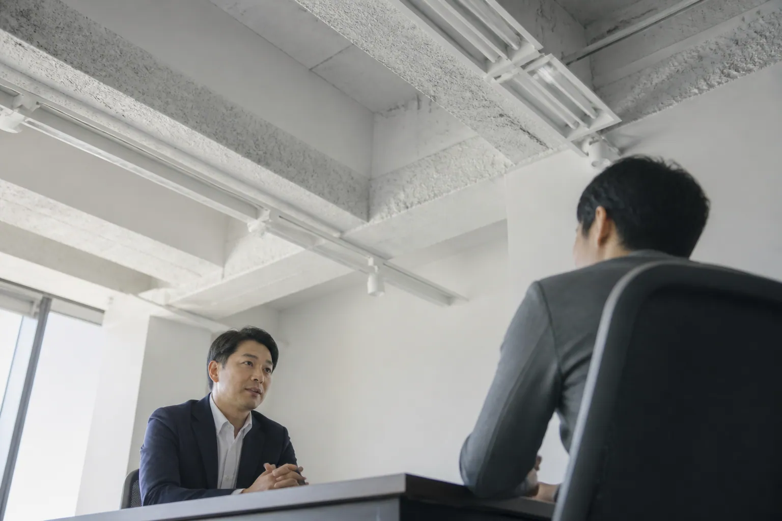 角を挟んで座り話す上司と部下