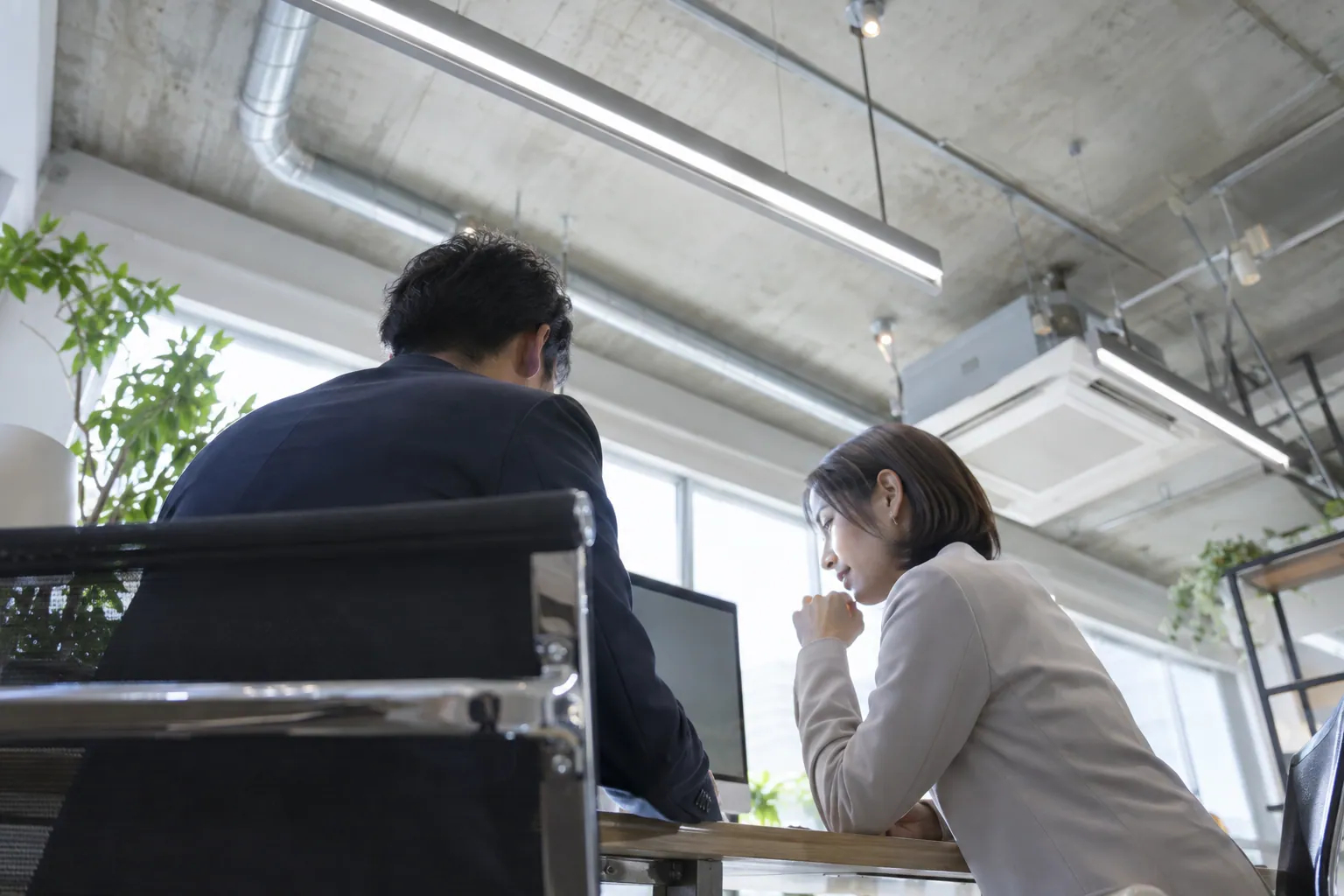 モニターを一緒に覗き込む採用担当者と現場責任者
